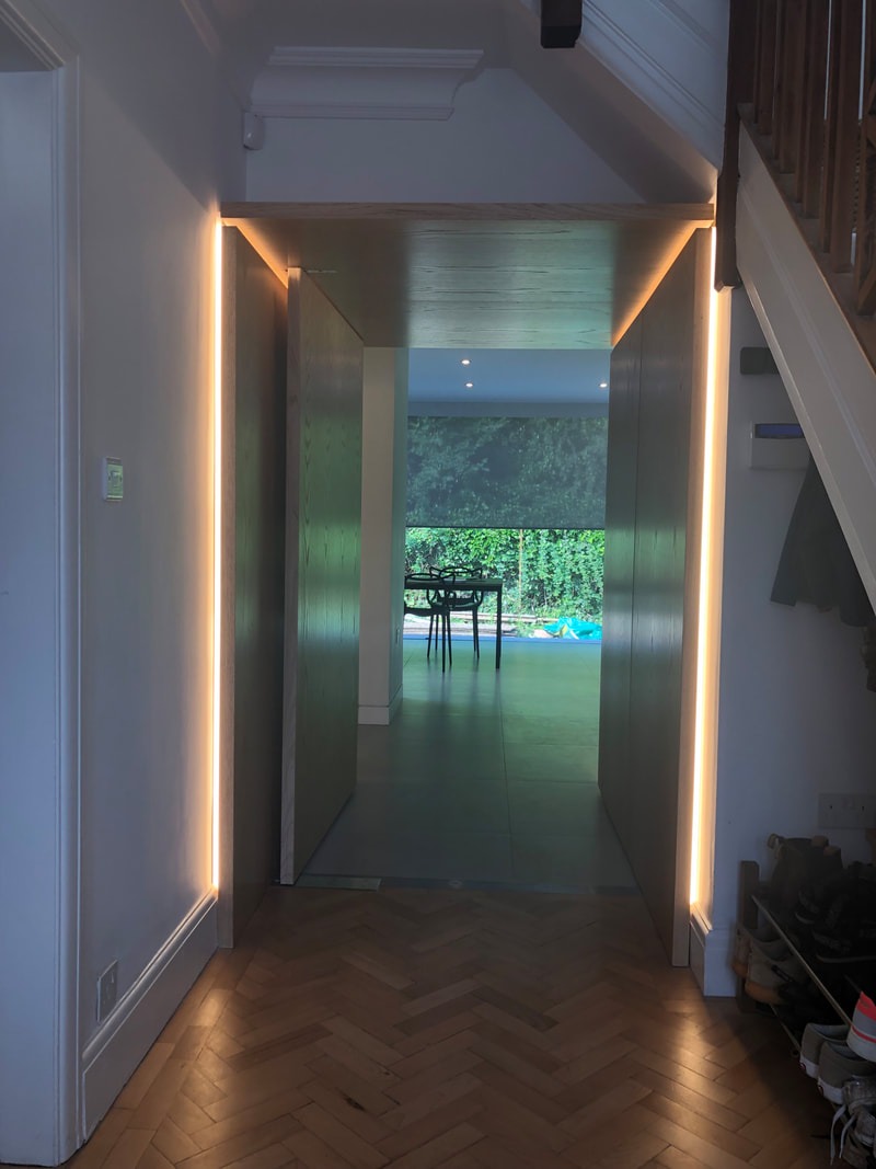 Oak-lined threshold with concealed doors and linear lighting
