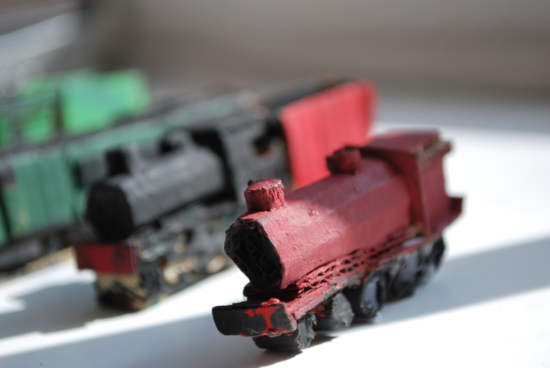 Handmade red locomotive with green train behind