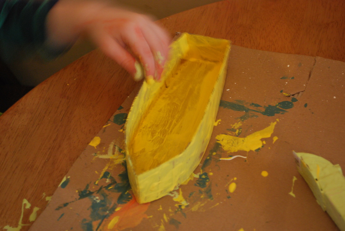 Handmade yellow boat being painted