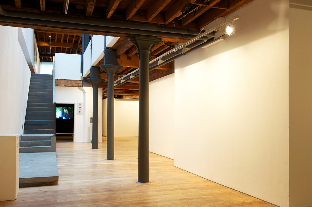 Main gallery — cast iron columns, concrete stairs, timber ceiling, white walls