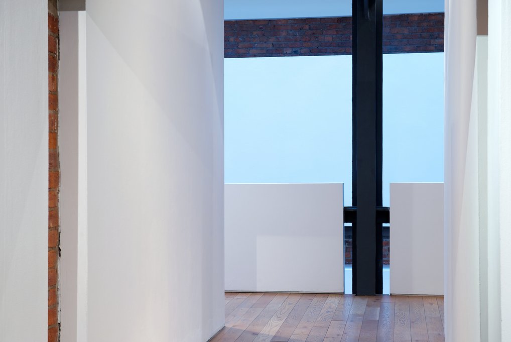 White planes framing view through brick opening to sky