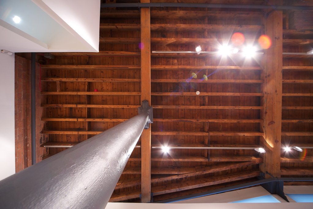 Looking up — cast iron column to timber beam ceiling