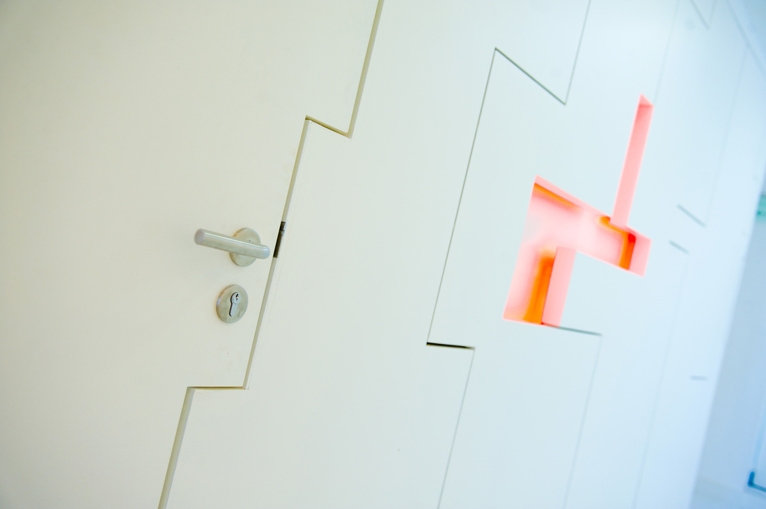 Interlocking door edge with illuminated cross visible beyond