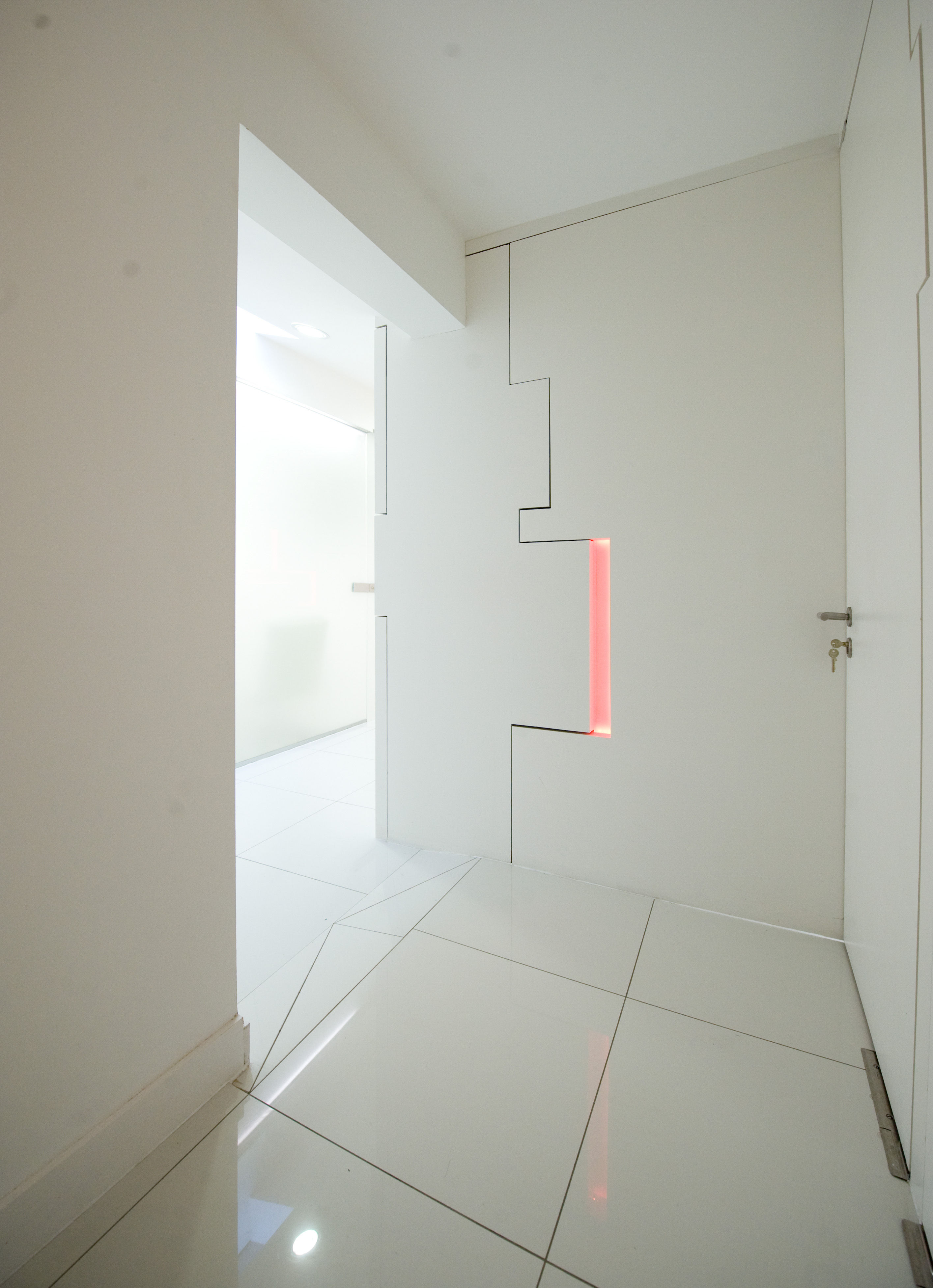 White corridor — interlocking door panels, illuminated red cross, reflective floor