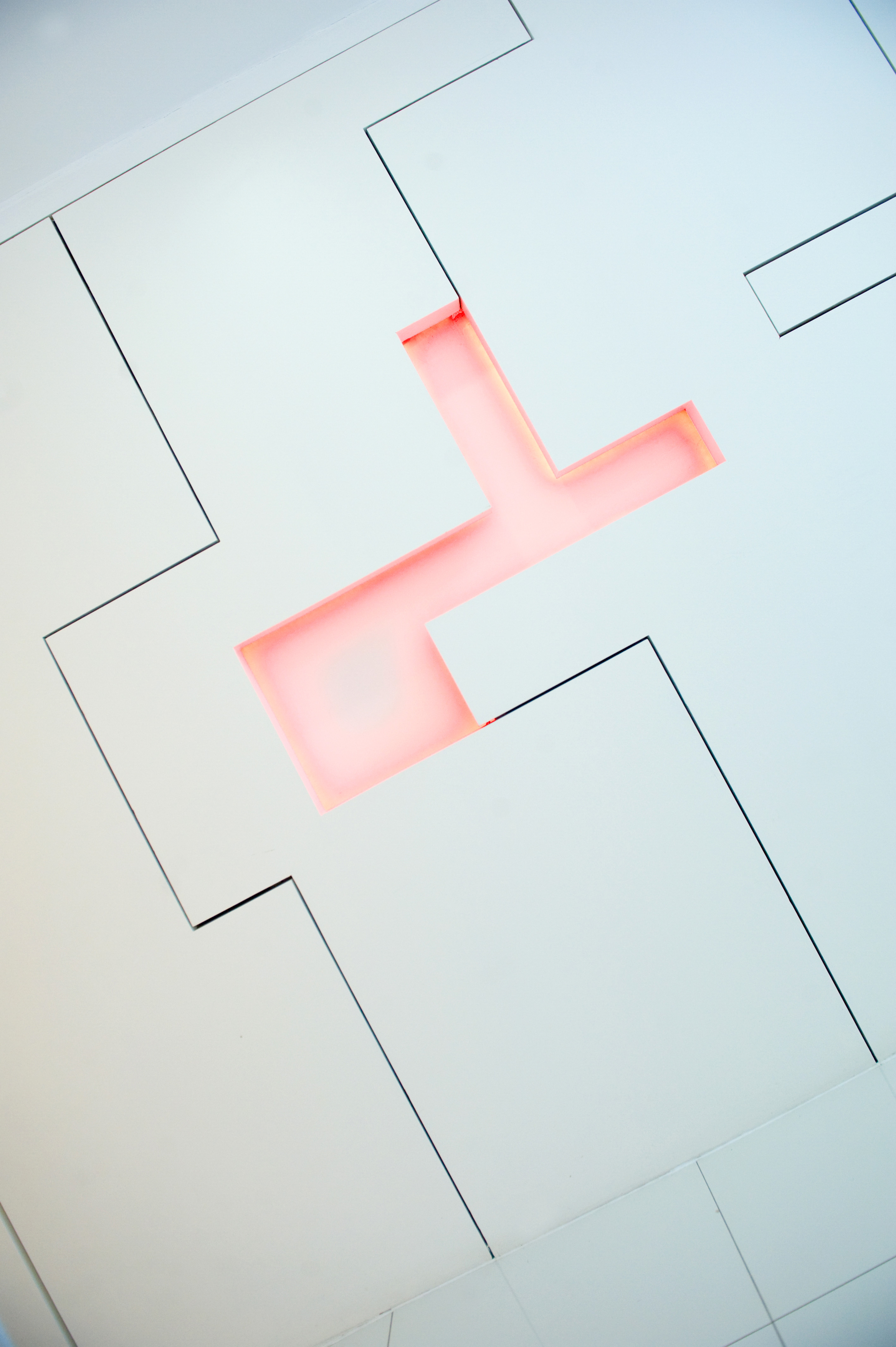 Close detail — illuminated cross form in white wall panel