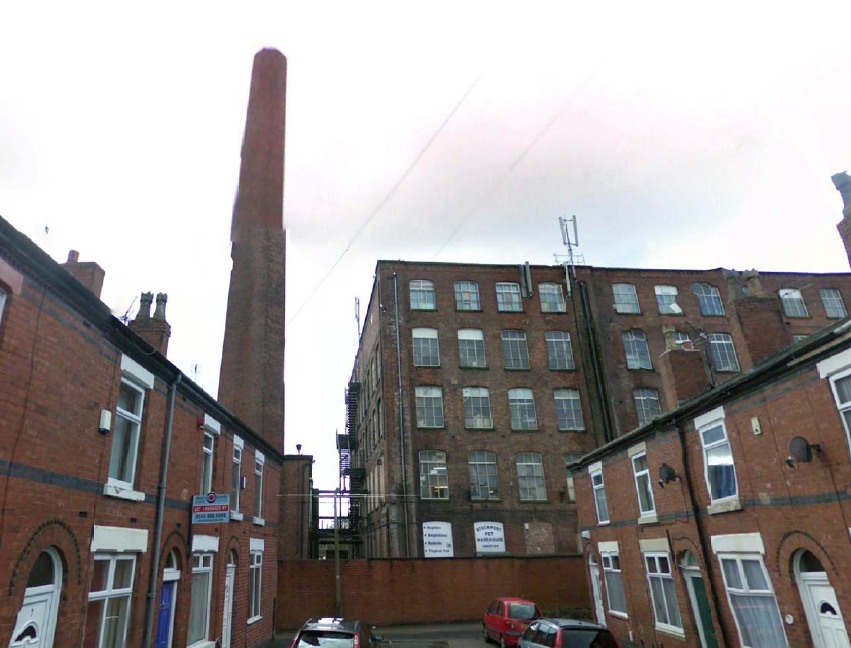 Hallam Mill — street view showing mill and chimney above terrace housing