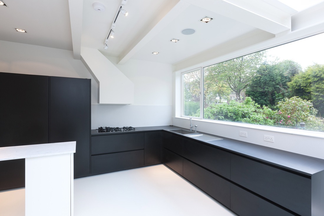 Minimalist black kitchen looking out to the garden through a large window