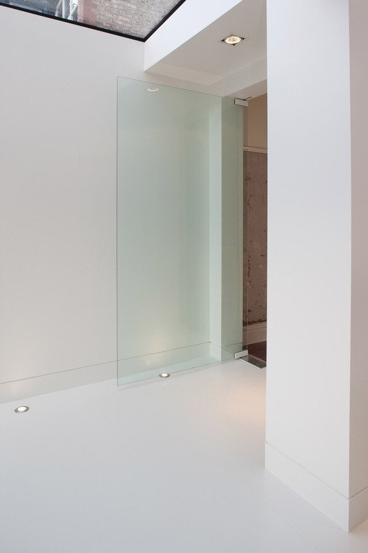 A frosted glass partition door within the white minimalist interior