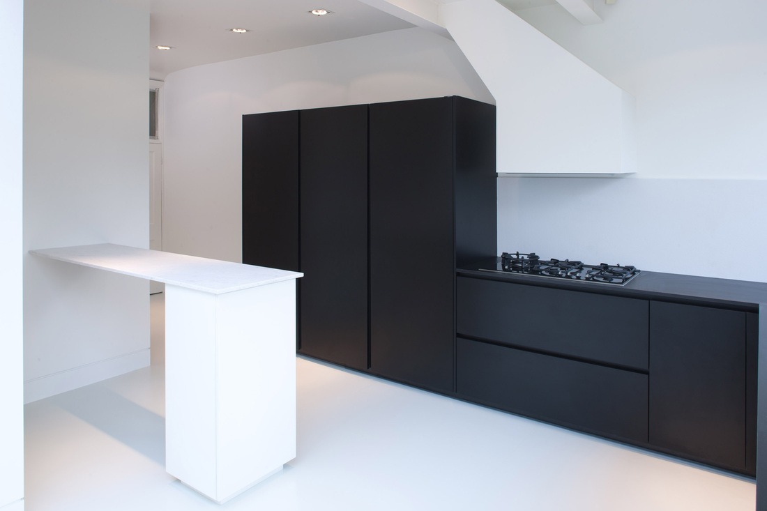 Matte black kitchen cabinets contrasted against a white island