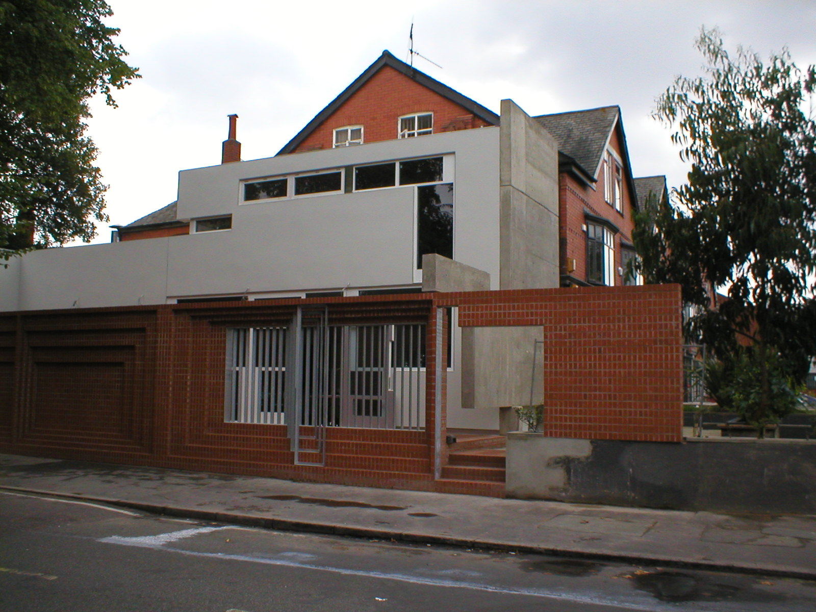 Side elevation — brick extension, concrete tower, galvanised screens, red brick