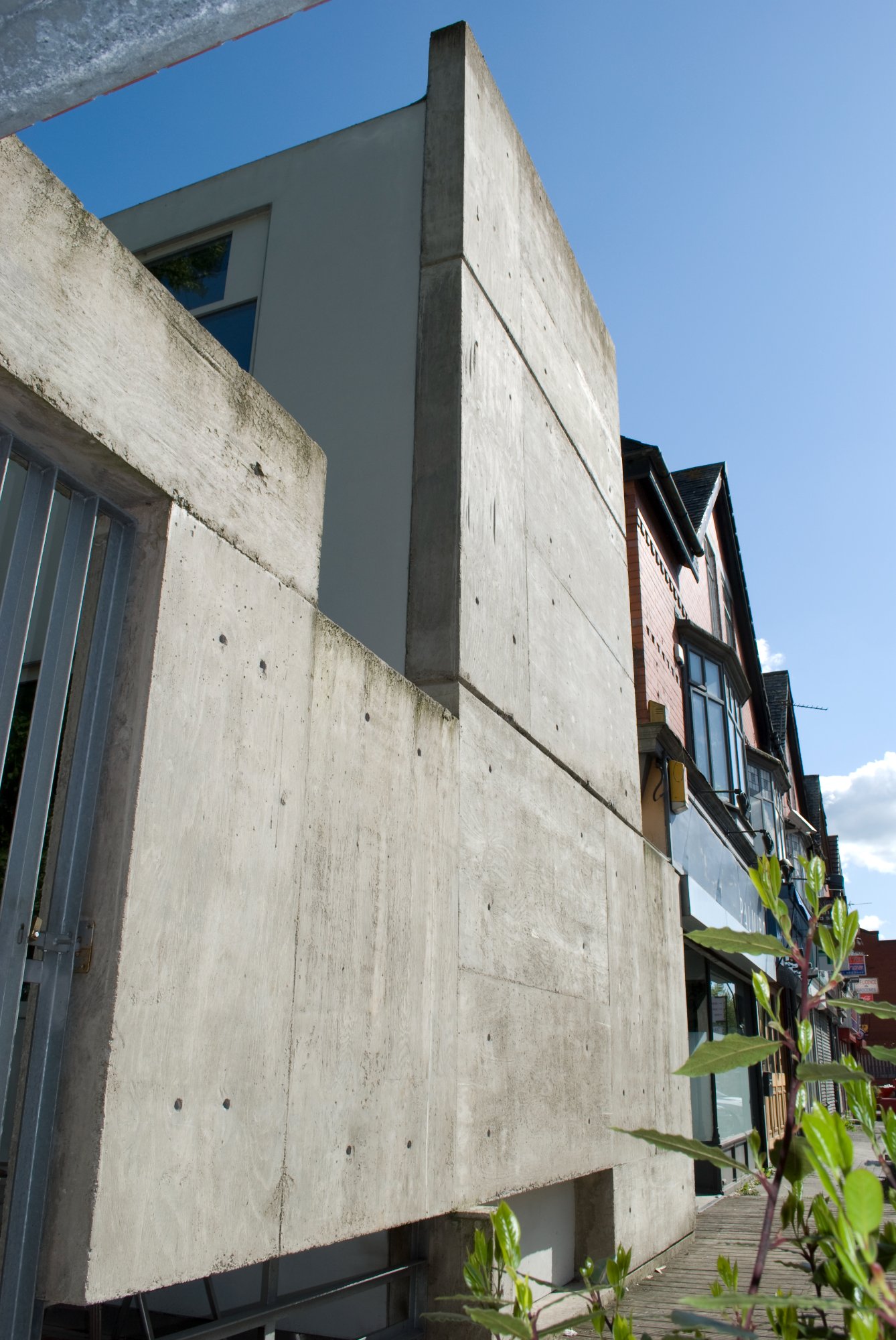 Board-marked concrete wall from low angle against blue sky
