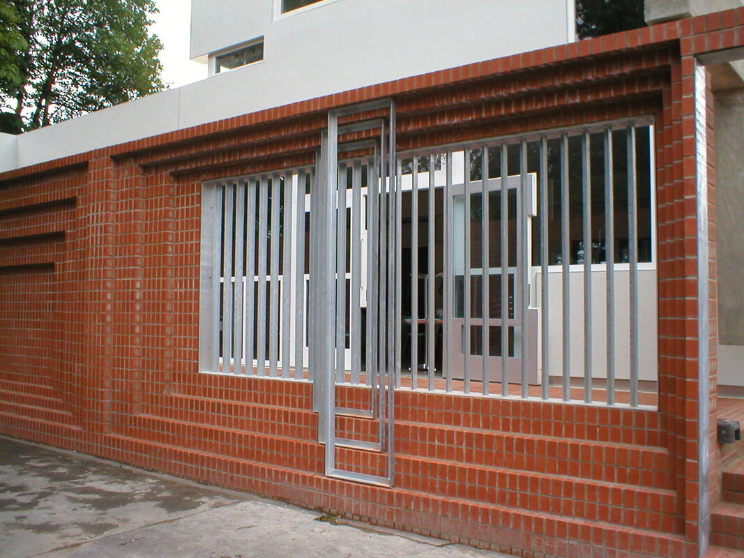 Galvanised steel screen in brick opening — close detail