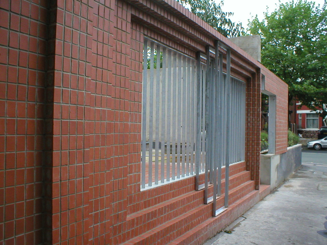 Galvanised steel louvred screen set within brick wall