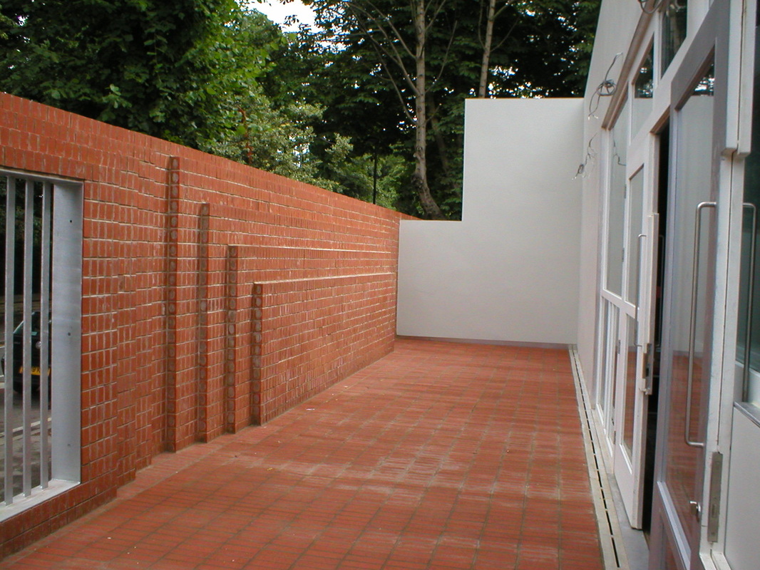 Brick terrace with quarry tile paving, steel screens, white render