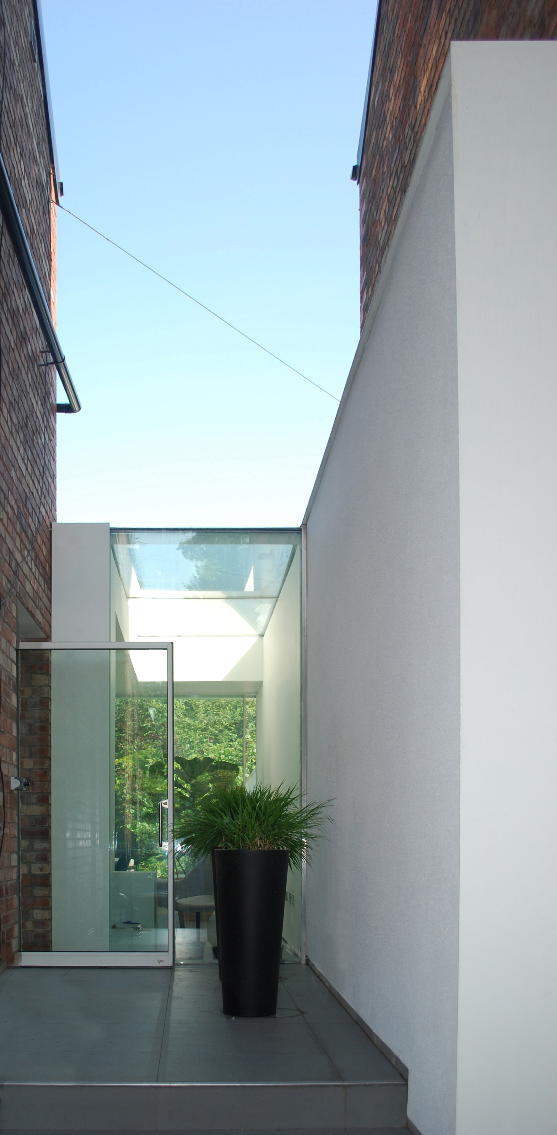 Close-up detail of the crisp white exterior frame and reflective glass against the brick house