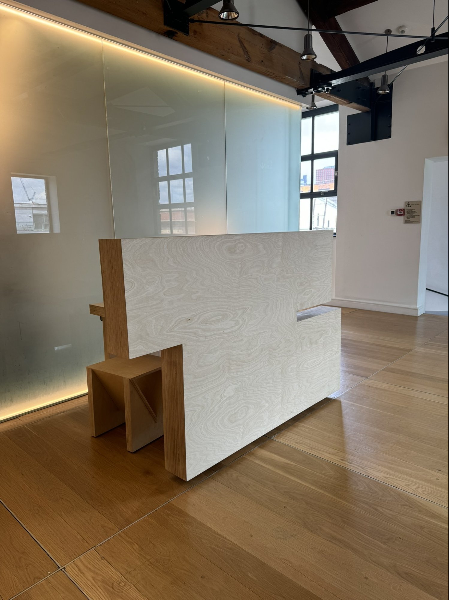 Bespoke timber landing furniture against translucent glass wall